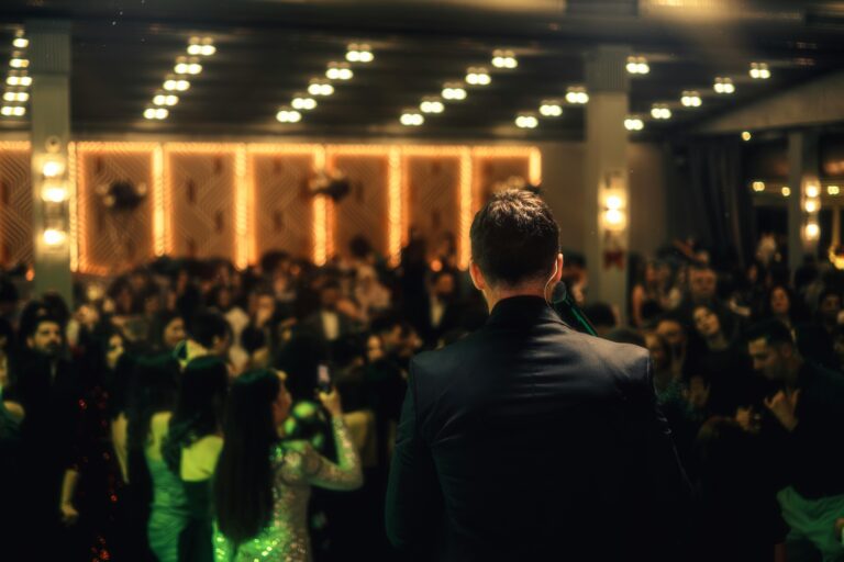 A speaker stands on stage addressing a crowd during an awards ceremony