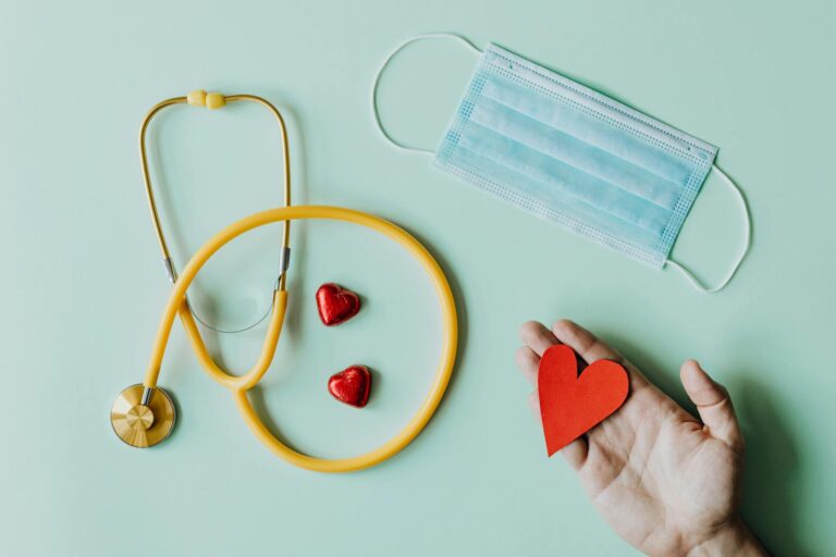 Stethoscope face mask and red heart shapes representing healthcare and medical insurance