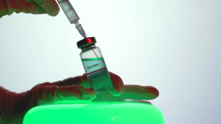 Syringe being drawn from vaccine vial in clinical setting