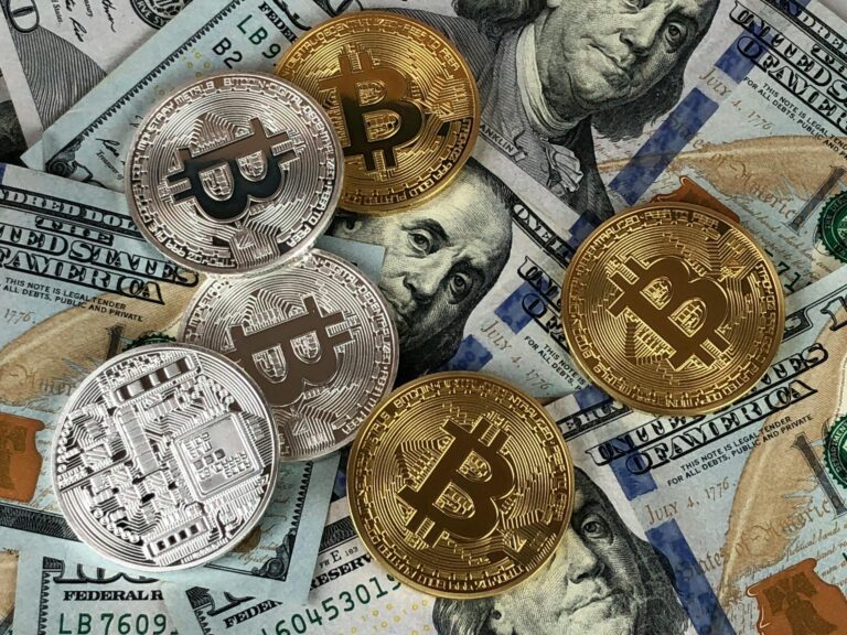 Bitcoin coins spread across US dollar bills representing the collision between cryptocurrency and federal regulation in the stalled Clarity Act debate