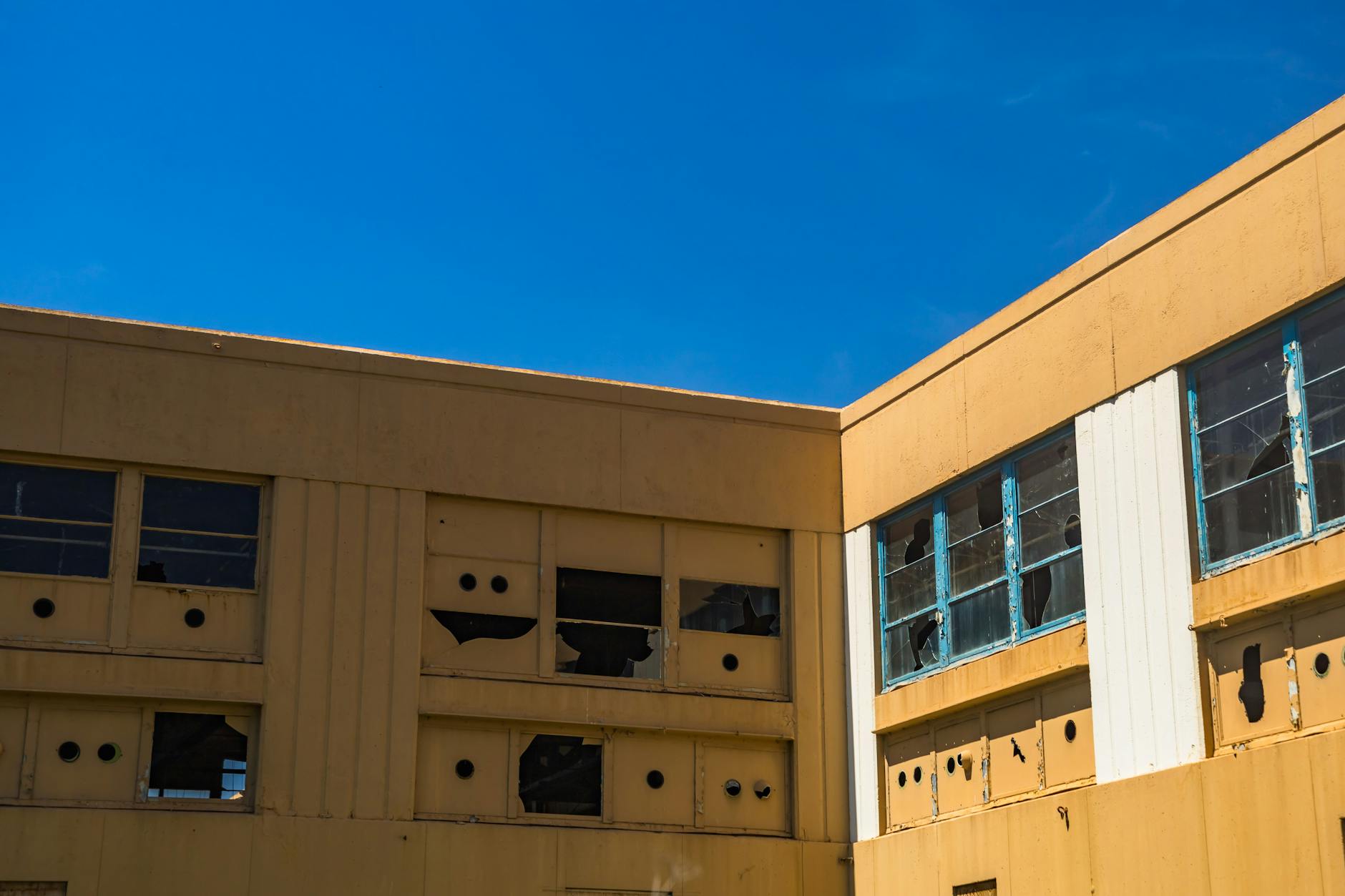 Abandoned building with broken windows representing institutional decline