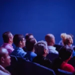 Audience watching a film in a dark movie theater