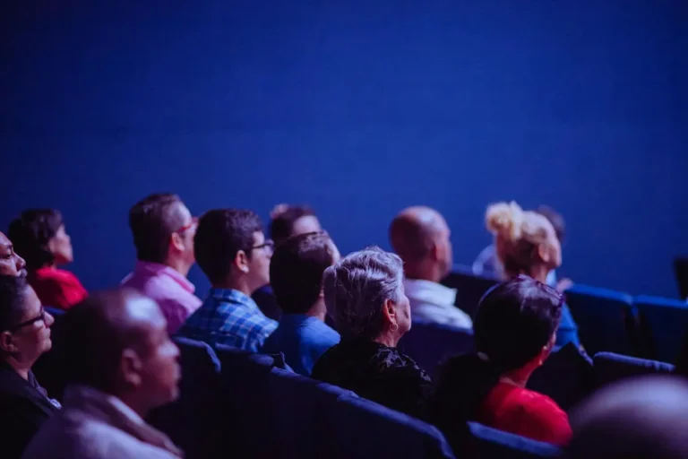 Audience watching a film in a dark movie theater