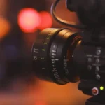 Close-up of a professional film camera lens representing AI-driven changes in film production costs