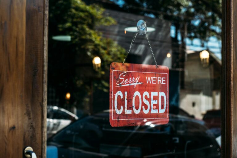A closed sign on a storefront door representing business shutdowns during Southeast Asia's fuel crisis