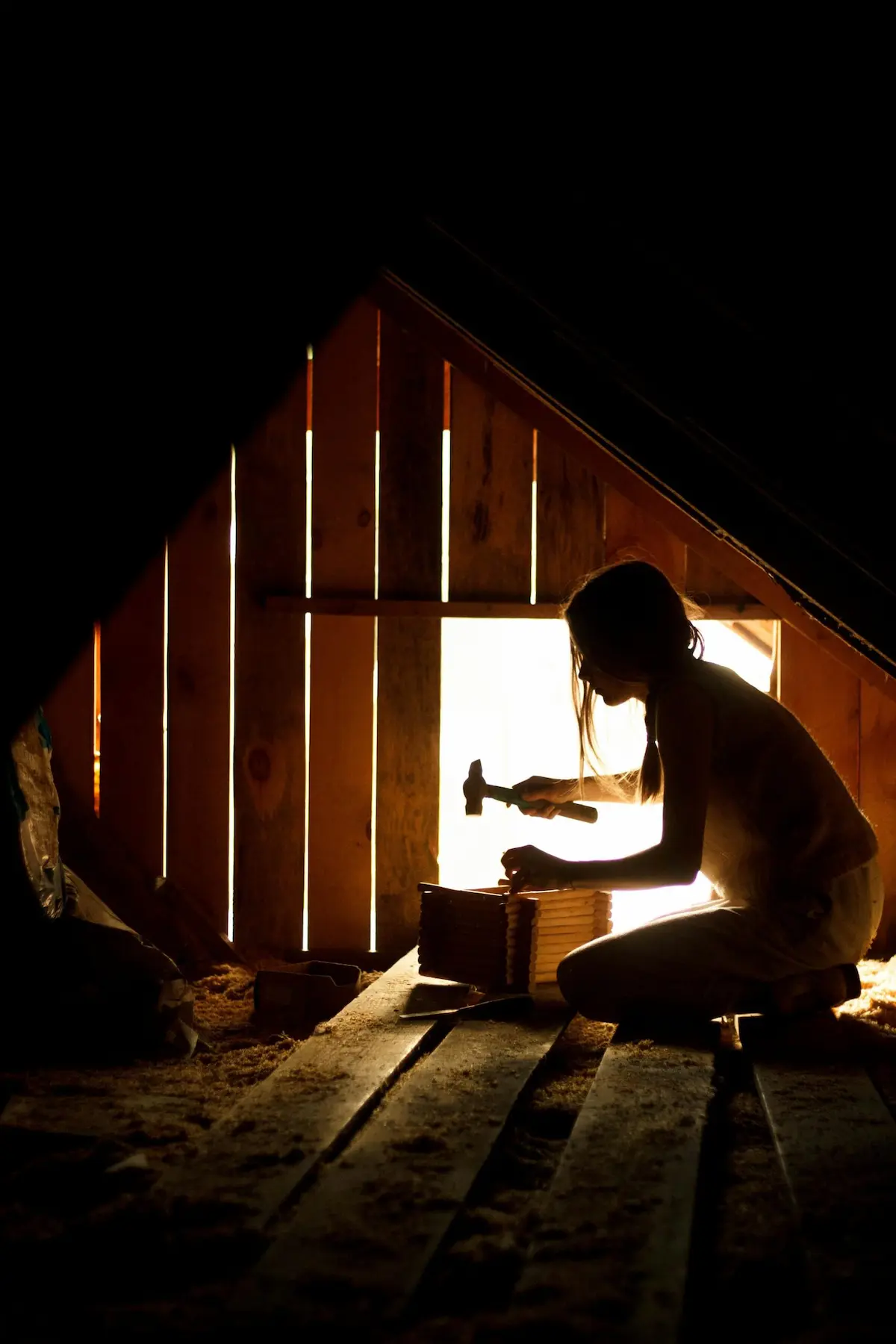 Woman working in an attic by window light